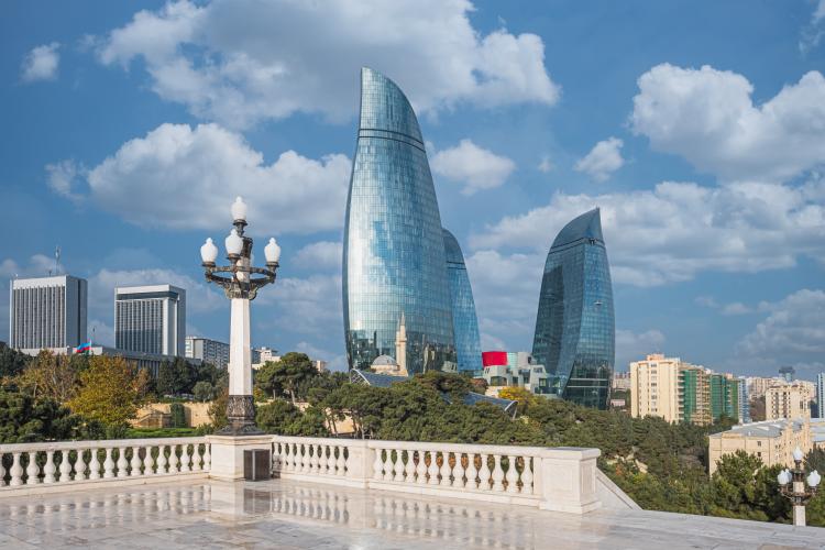 Baku the capital. Skyscrapers background. In the foreground green bushes and a square higher up. 