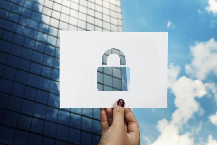 padlock ona perforated paper in front of modern glass building