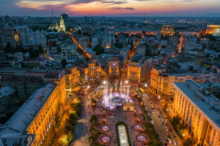 From above, the city is highlighted by light, a big square is visible.
