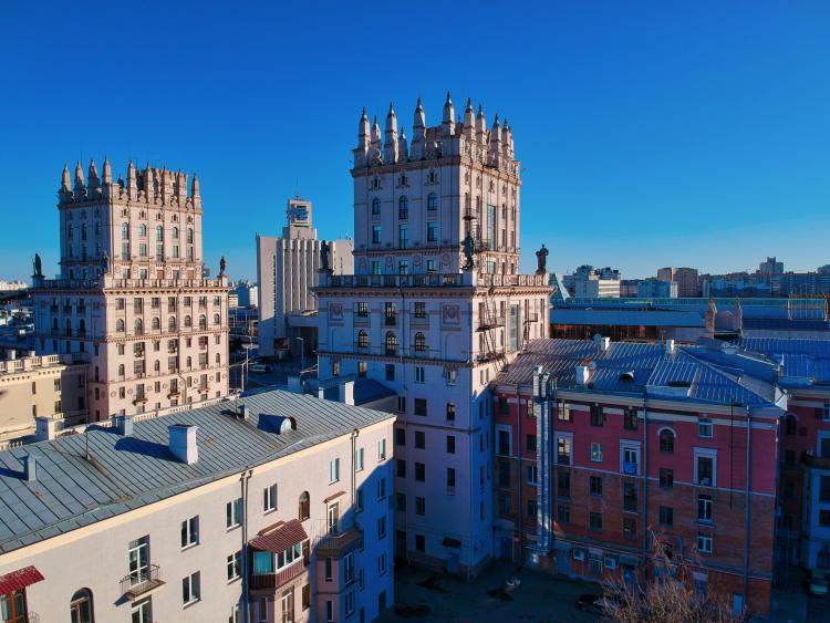 High, old buildings. Photo taken from a height in line with the buildings' top. Blue sky in the background. 