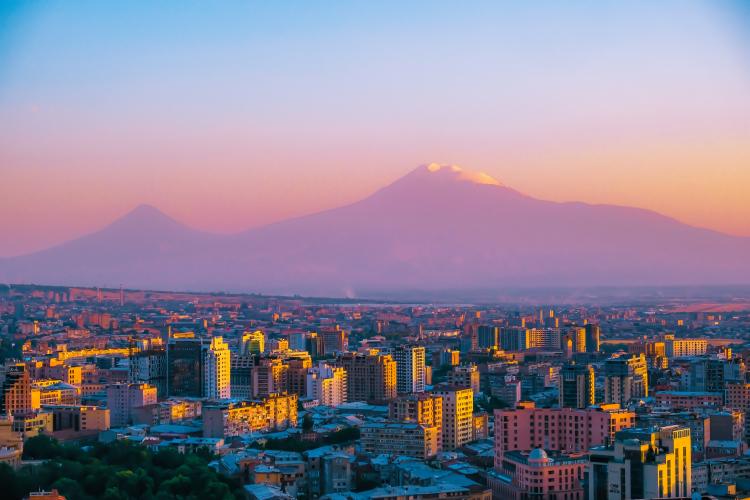 A photo of Yerevan with mountains in the background.
